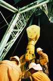 Mining Photo Stock Library - workers in PPE inspecting the derrick on a drill rig.  shot at night and looking up the derrick for full height.  vertical shot ( Weight: 1  New Image: NO)