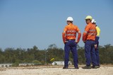 Mining Photo Stock Library - three mine site workers in full PPE in discussion.  workers out of focus.  vertical shot. ( Weight: 1  New Image: NO)